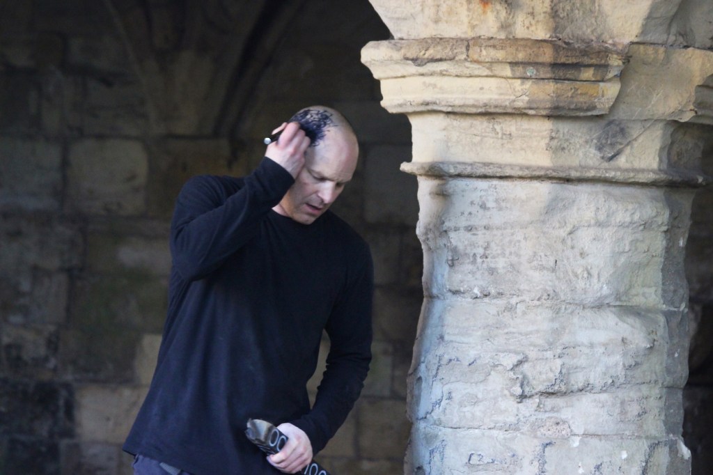  Image of man with ink on head, moving around the arch.